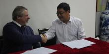 Principal Dave Morgan signs sister school agreement with Fang Wangdong of the Lin’an High School in China.